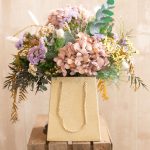 Bolsa dorada con flores preservadas